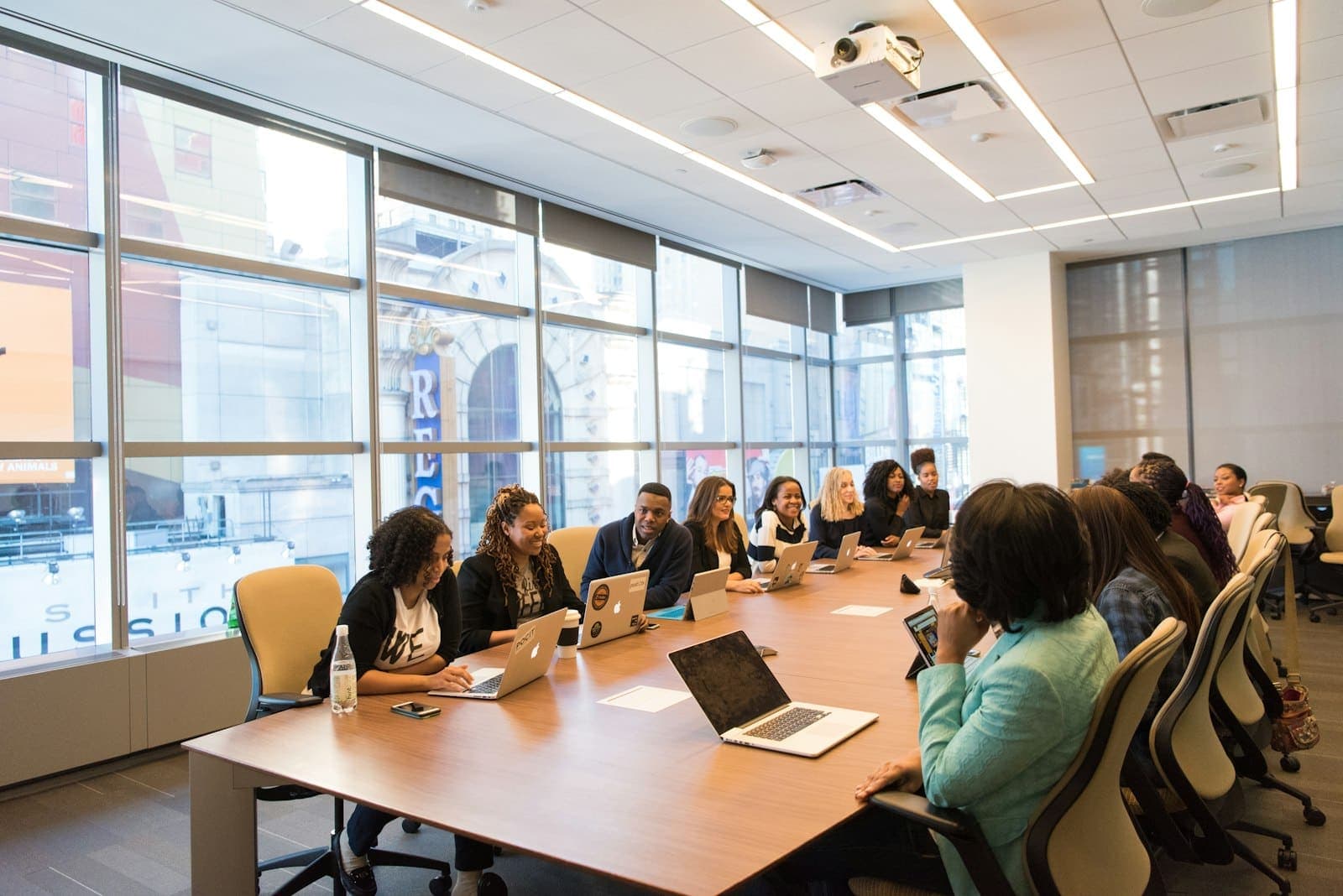 Turma em treinamento corporativo com notebooks em uma sala de reunião